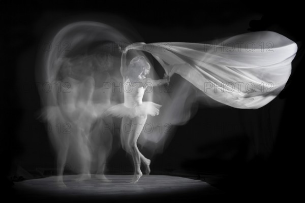 Ballerina in motion with flowing fabric, elegant and graceful in an artistic image, long exposure, studio shot, Mindelheim, Bavaria, Germany