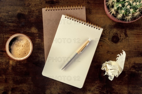 Notebook with a pen, coffee, and plant, overhead flat lay shot on a rustic wooden desk, with a sheet of crumpled paper, Food photography, Food photography