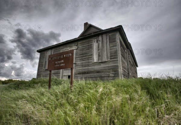 Abandoned Farm with storm clouds in the Canadian Prairie