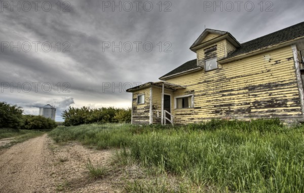 Abandoned Farm with storm clouds in the Canadian Prairie