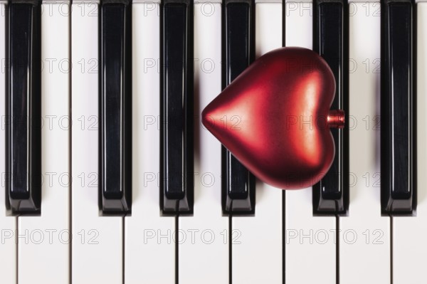 Detail of piano keyboard and red heart