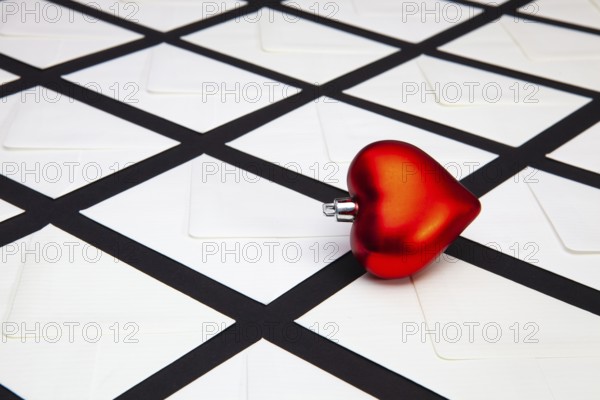 Composition with white envelopes and red heart on the table. The photo suitable for various holidays and anniversaries
