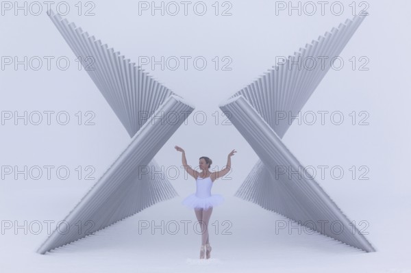 Ballerina poses gracefully between a futuristic sculpture in winter in sub-zero temperatures, Emmendingen, Baden-Württemberg, Germany