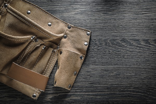 Leather tool belt on wooden board
