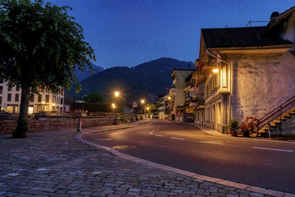 Empty street at twilight with illuminated buildings and street lights, city, vilage, cityscapes, streets, old architecture, old buildings, Interlaken, Switzerland