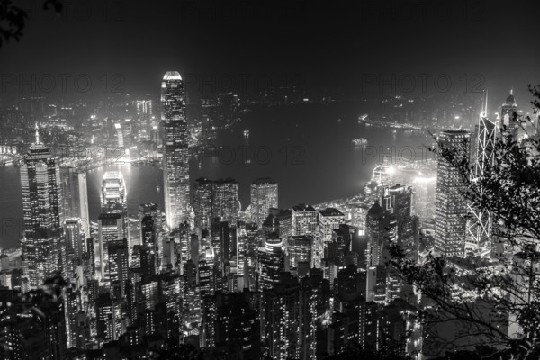 Victoria Harbour skyline by night from Lugard Road Lookout at Victoria Peak, the highest mountain in Hong Kong Island. Panorama of skyscrapers and towers of Hong Kong in black and white