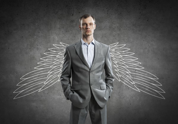 Young businessman with chalk drawn wings behind his back