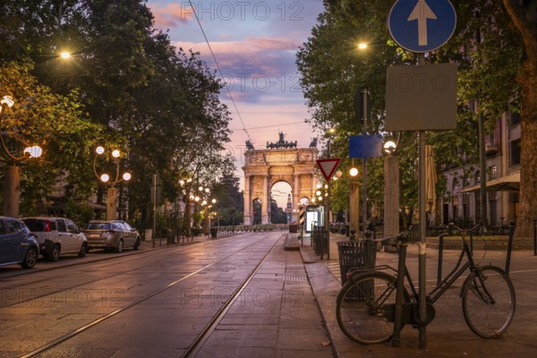Road to the Arch of Peace and tram rails at sunrise in Milan, Italy