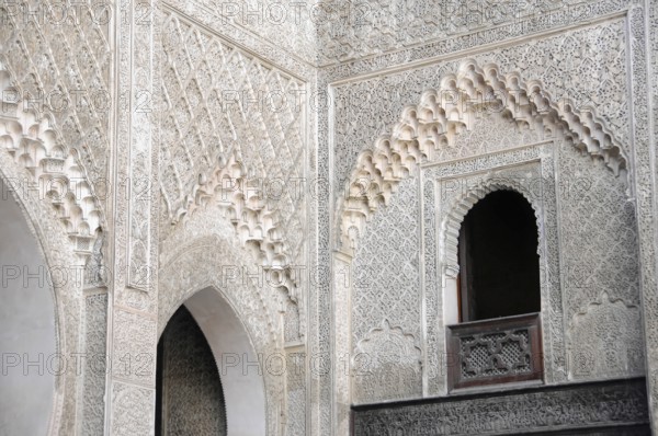 Fes, Northern Morocco, Morocco, Richly decorated wall with detailed patterns and a small window arch, Fes, Northern Morocco, Morocco