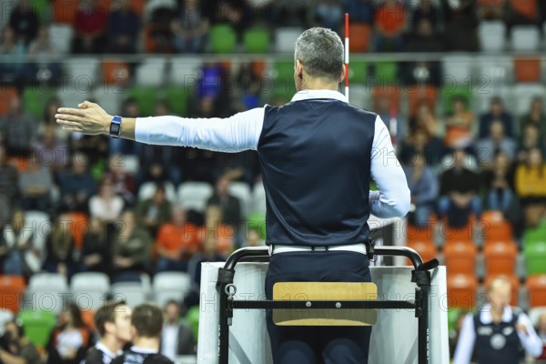 Volleyball first referee indicates a point for the team on the left