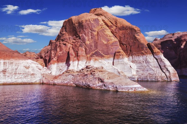 Lake Powell is surrounded by magnificent red hills. Walk on the boat at sunset. Scenic huge artificial water basin of the Colorado River, USA