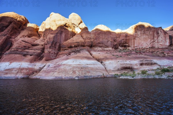The Colorado River and Antelope Canyon. Grandiose cliffs - red sandstone outcroppings. Tour on a tourist boat on an artificial reservoir Lake Powell. Concept of active and photo tourism