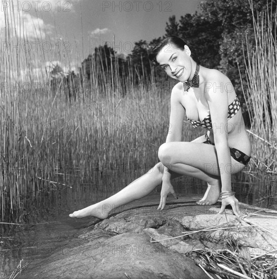 In the 1950s. Beutiful Iris Johansson on a summer day wearing men's neckties as a bikini-like outfit. She is also working in a men's fashion store, selling neckties. Sweden 1951 Kristoffersson ref BC68-3