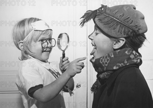 Playing doctor in the 1940s. A little girl is the doctor in this game and looks down her brothers throat like a real doctor. Sweden 1948