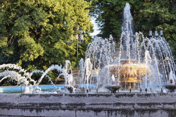 An old fountain with a large bowl in the centre and jets of different shapes in the resort park of the city