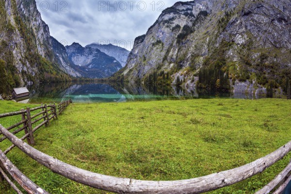 The concept of active tourism and ecotourism. Bavarian Alps. Magic blue lake Obersee and fenced path to it