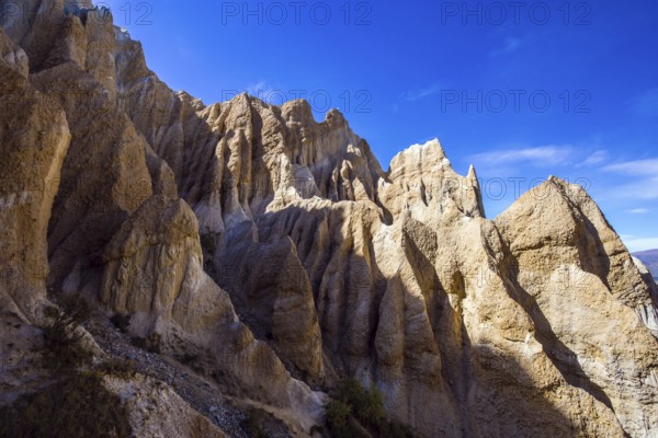 Jagged sharp pinnacles and ridges separated by narrow ravines. New Zealand, South Island. Clay Cliffs. Grandiose natural land formations. The concept of extreme, natural and photo tourism