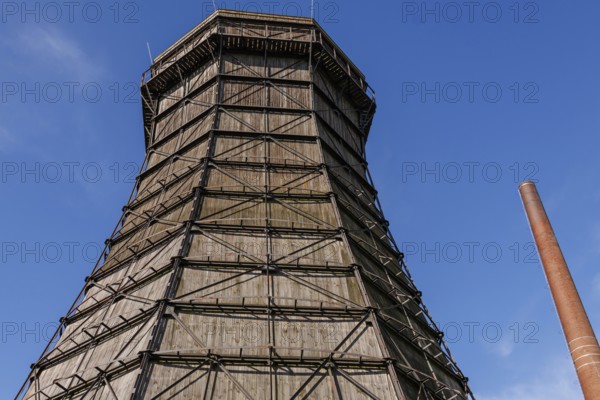 Large wooden cooling tower next to a chimney under a blue sky, Essen, Ruhr area, Germany