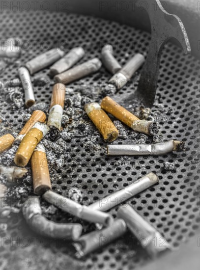 Smoked cigarettes butts in a dirty ashtray. Unhealthy life concept