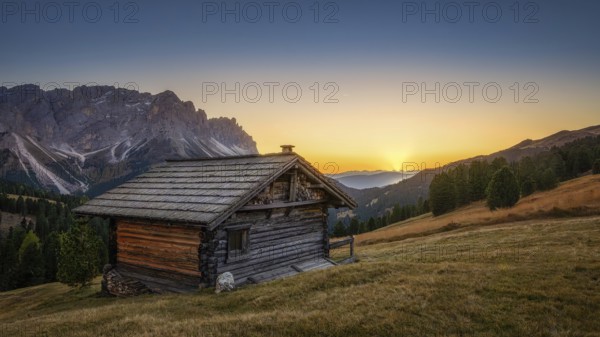 Passo Erbe under the mountain Peitlerkofel, or Sass de Putia in the light of the setting sun with wood hut