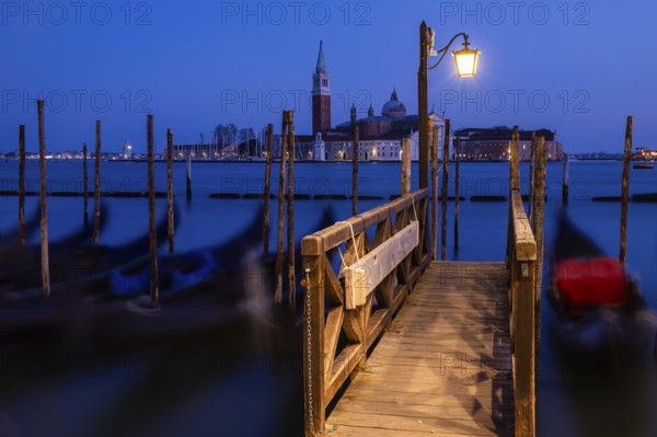 Venetian gondolas, boat dock at St Mark's Square, church of San Giorgio Maggiore in the background, blue hour, long exposure, Venice, Veneto, Italy