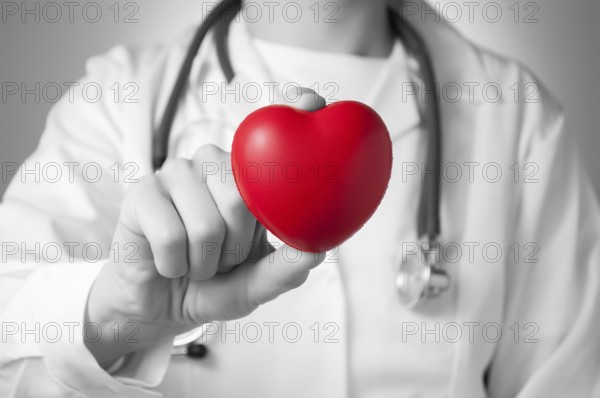 Red heart in the hand of a doctor