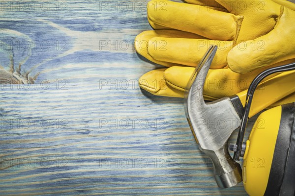 Composition of protective workwear claw hammer on wood board construction concept