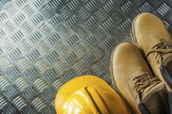 Waterproof boots hard hat on corrugated metal sheet