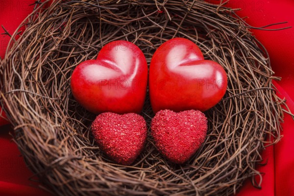 Little cozy nest with four red hearts. Family concept - attachment parenting. Parents and children