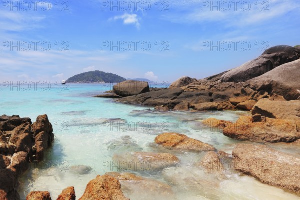 Similansky islands, Andaman Sea, Thailand. The thinnest white sand of a beach adjoins with huge brown rocks and azure water