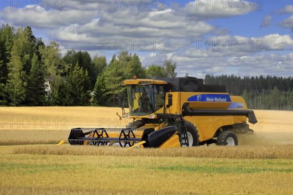 Autumn harvest 2020 begins in Finland: farmer harvesting barley with New Holland CS540 combine in Salo, Finland. August 1, 2020