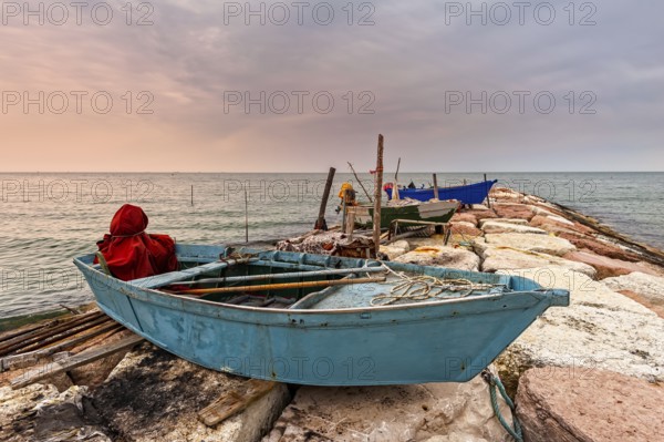 Fishing boat moored on cliff at sunset. Venice, Italy