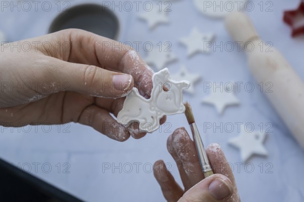 Master class of painting Unrecognizable artist do it yourself air dry clay crafts for Christmas tree decor holiday. Decoration gift idea Handmade children craft. Step by step instruction of painting, pressing figures