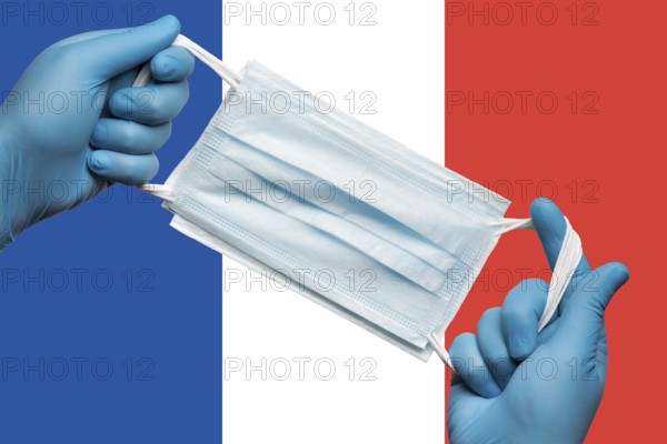 Doctor holding respiratory face mask in hands in blue gloves on background flag flag of France or French Tricolour. Concept coronavirus quarantine and pandemic outbreak. Medical bandage for human face
