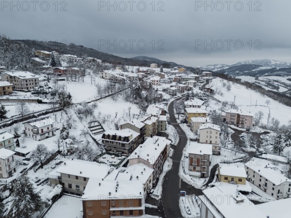 Aerial view of bore, a village in the province of parma covered by snow in december 2024, showcasing the winter landscape of the italian apennines