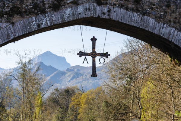 Cross hanging on old Roman stone bridge in Cangas de Onis, Asturias, Spain
