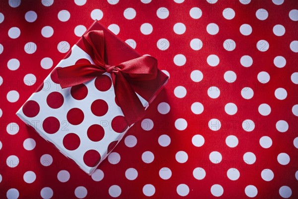 Wrapped box with present on polka-dot fabric celebrations concept