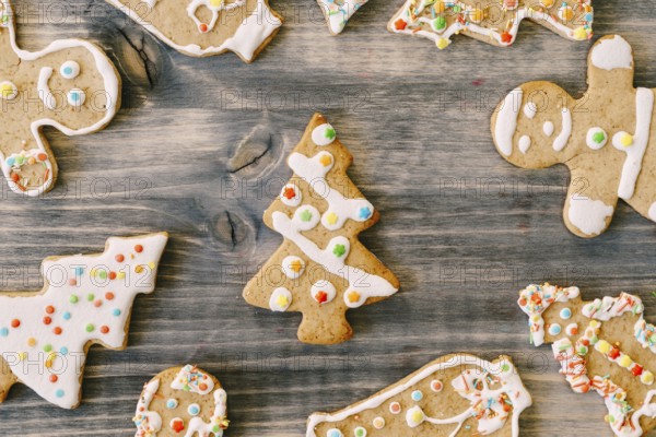 Colorful Christmas gingerbreads in the shape of Christmas trees and little men decorated with color icing.
