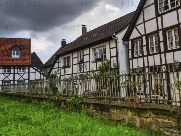 Large half-timbered houses with a fenced garden and clouds in the sky, Herten, North Rhine-Westphalia, Germany