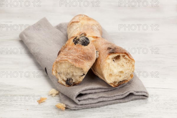 Delicious pastry on wooden table. Olive baguette