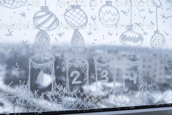 Sustainable responsible holiday decor. Christmas advent candle painted on window glass indoor at home. Christmas winter decoration. White pattern. Snow art tracery on season. Diy. Hygge home