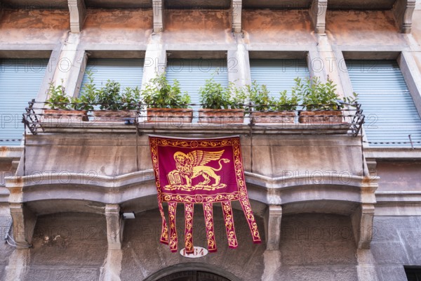 Markuslöwe, Flagge mit dem Wappen von Venedig hängt an einem Erker, Venedig, Italien
