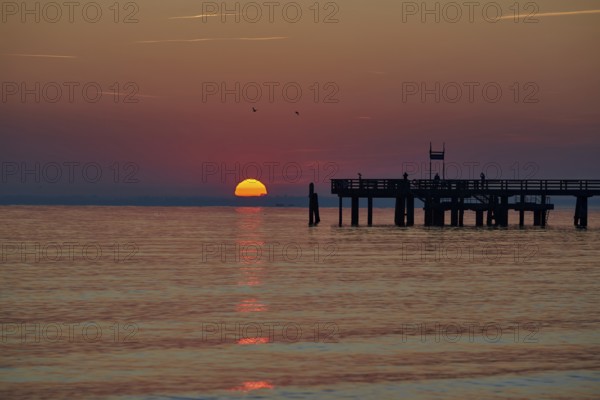 Sunrise over the sea at the pier of the Baltic Sea resort, Boltenhagen, Mecklenburg-Vorpommern, Germany
