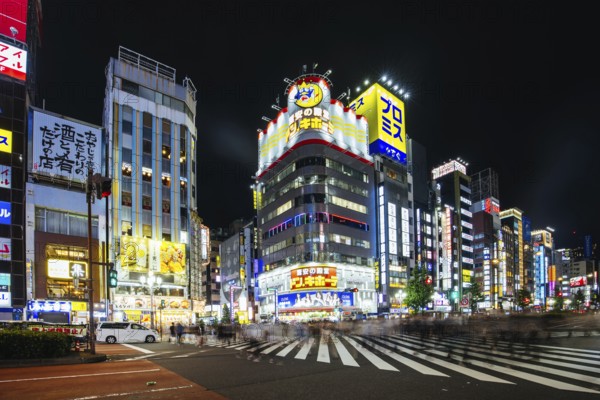 TOKYO, JAPAN, SEPTEMBER 16 2024: Neon signs illuminate with traffic in Tokyo's busy Shinjuku neighborhood at night in Japan