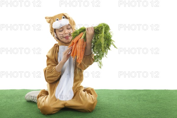 Child dressed as easter hare with bunch carrots isolated over white background