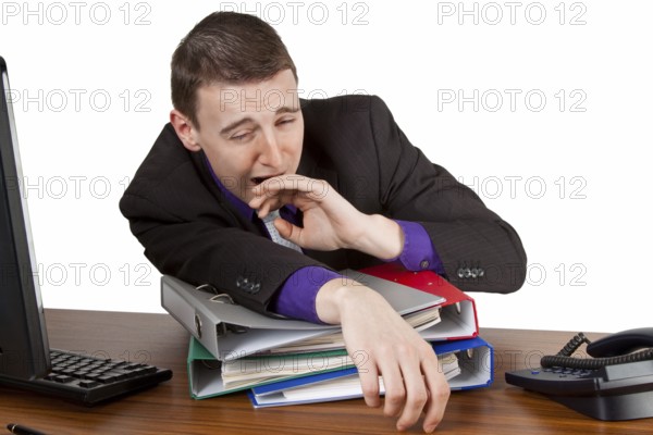 Young businessman yawning at his desk - Freisteller Young businessman yawning at his desk - isolated