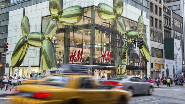 NEW YORK CITY - JULY 29, 2014: Modern HM shop in 5th street New York City with rushing cabs and people in front