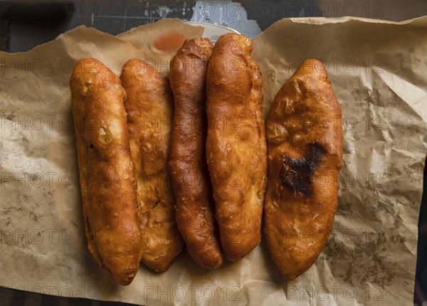 Fried pies lie on craft paper on the table