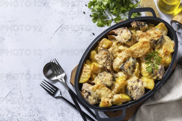Baked mackerel with potatoes and cheese on a marble tabletop. Top view flat lay background. Copy space