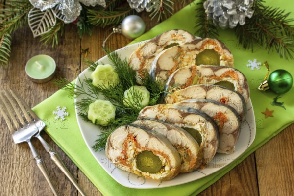 Festive snack. Baked mackerel roll stuffed with cheese, carrots, eggs and pickled cucumber, served on the Christmas table